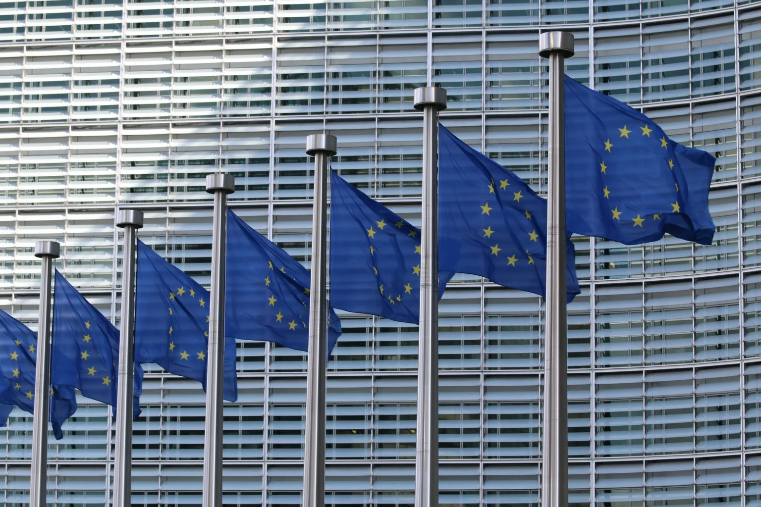 European Union flags outside the Berlaymont building in Brussels, illustrating EU ESG regulation and interim legal developments